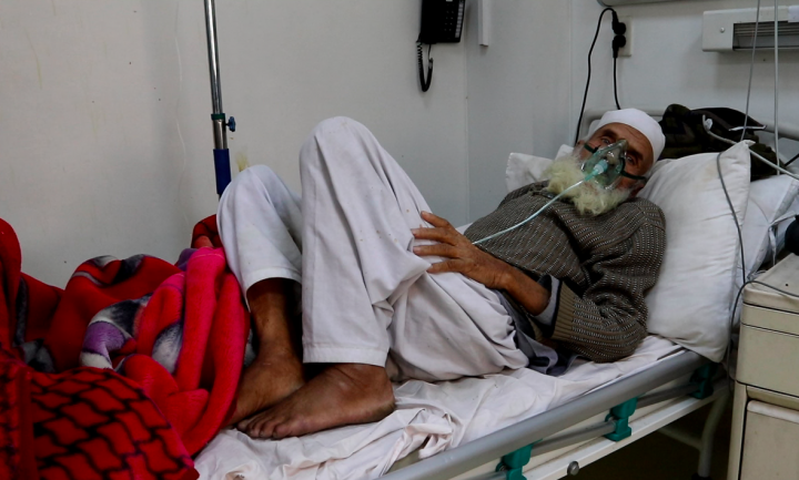 Afghan man laying in a hospital bed