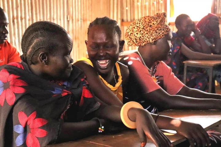 Women smile while taking part in a workshop for gender-based violence awareness