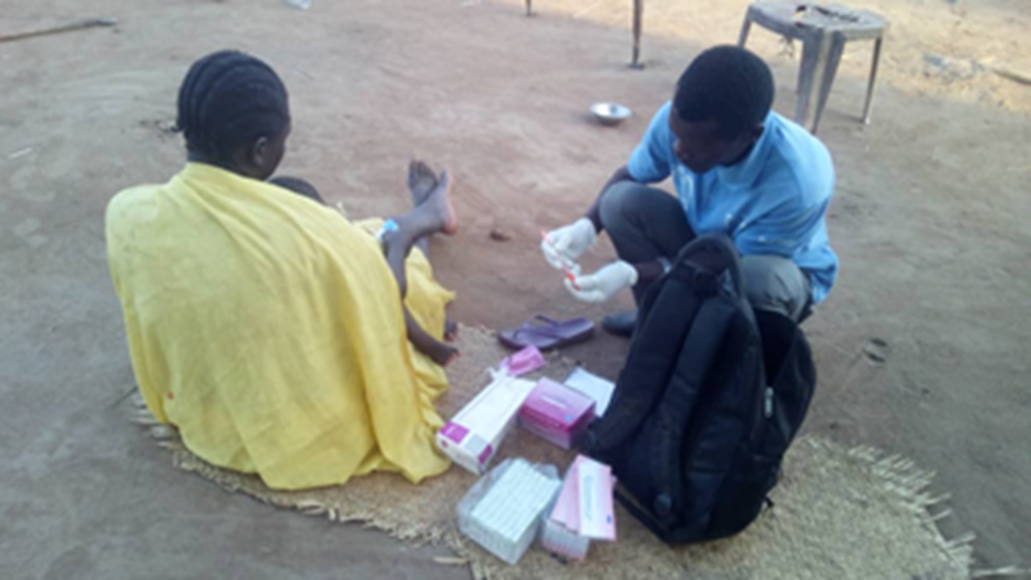 A Boma Health Worker treats a sick child being held by their mother in Terekeka, South Sudan