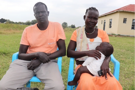 Cecilia, sits next to her husband Thomas holding their 8 month old daughter.