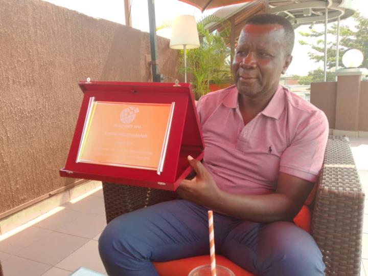 Joseph receives a plaque in appreciation of his dedicated service to HealthNet TPO and the people of Burundi.