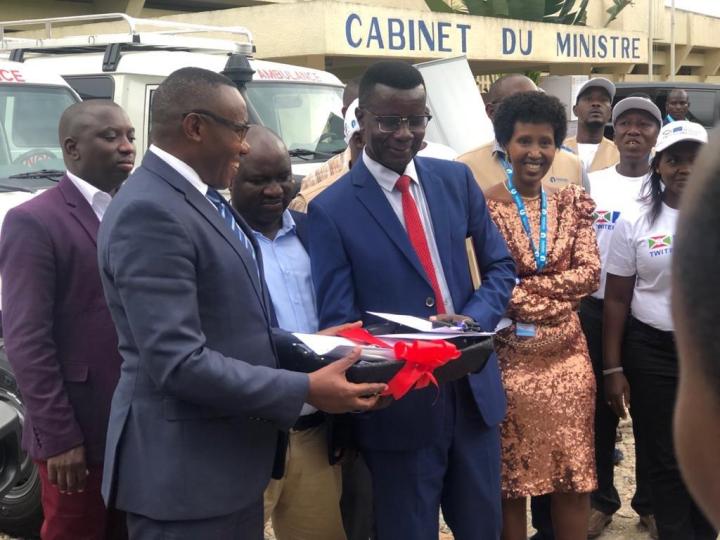 Joseph Nduwumwami presents with the Minister of Health during a handover of ambulances in 2021.